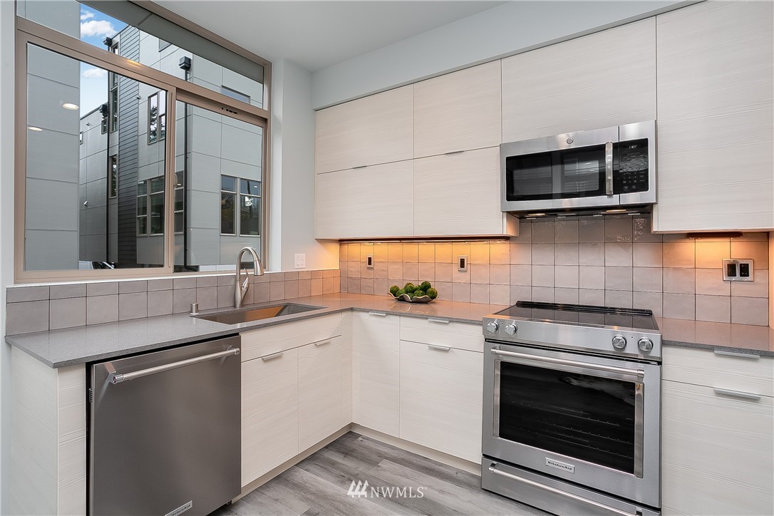 5257 Fauntleroy Way Southwest Seattle, WA 98136 - Photo 10 of 27 a kitchen with stainless steel appliances a stove sink and microwave