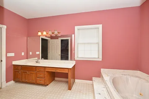 a bathroom with a tub sink and mirror