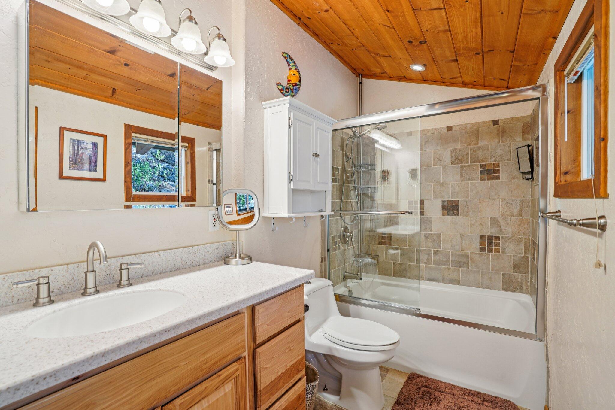 25361 Skyline Way Idyllwild, CA 92549 - Photo 25 of 42 a bathroom with a sink a toilet a mirror and shower