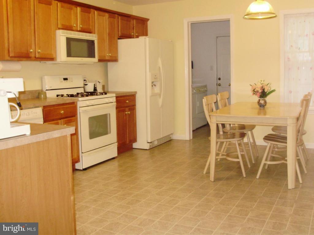 608 Wallingford Road Lititz, PA 17543 - Photo 7 of 30 a kitchen with stainless steel appliances a stove a sink a microwave a dining table and chairs