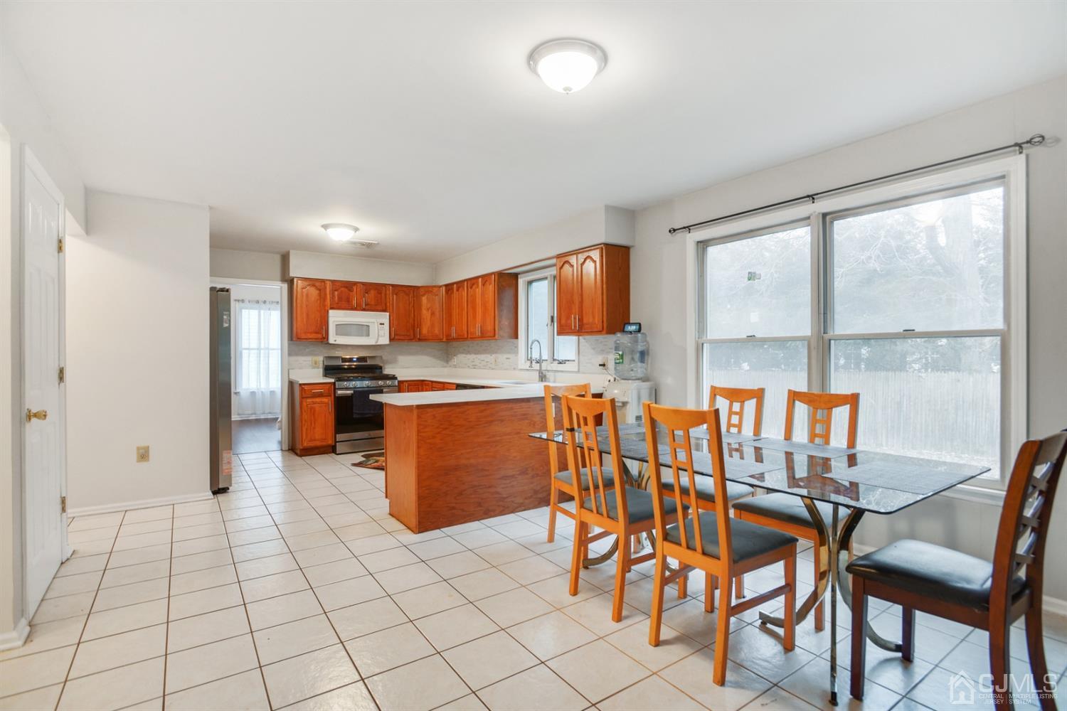 188 Plainfield Road Edison, NJ 08820 - Photo 6 of 16 a kitchen with stainless steel appliances kitchen island granite countertop a table chairs sink and cabinets
