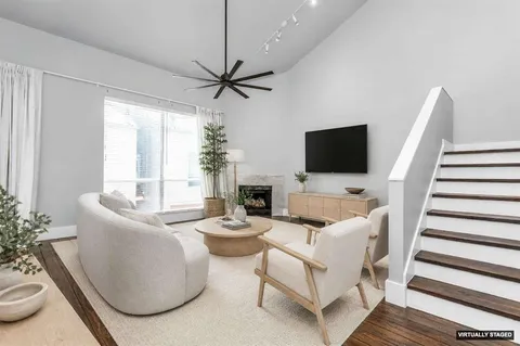 a living room with furniture a flat screen tv and a large window