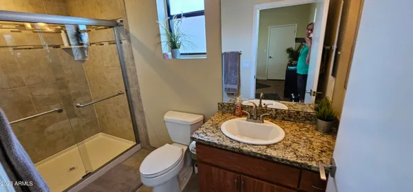 a bathroom with a granite countertop sink toilet and shower
