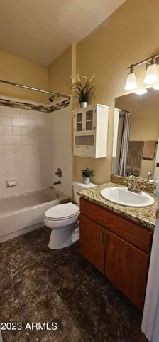 a bathroom with a granite countertop sink a toilet a mirror and shower