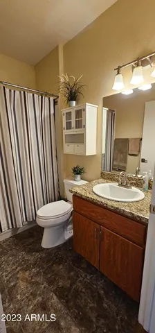 a bathroom with a granite countertop sink toilet a mirror and a bathtub