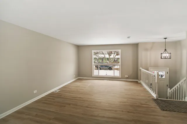 a view of a room with wooden floor and windows
