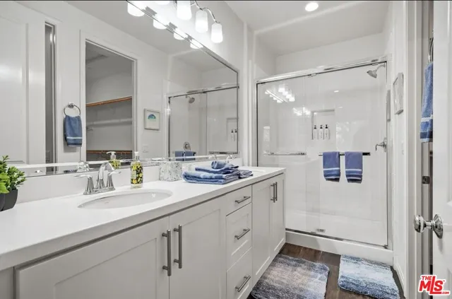 a bathroom with a double vanity sink mirror and shower