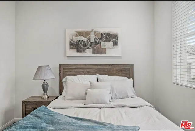 a bed with a white comforter and pillows