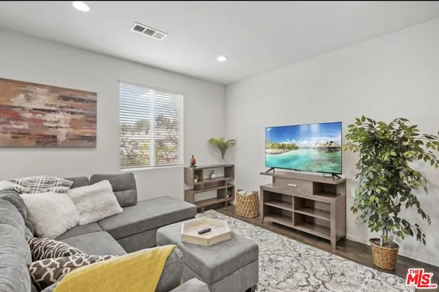 a living room with furniture a window and a flat screen tv