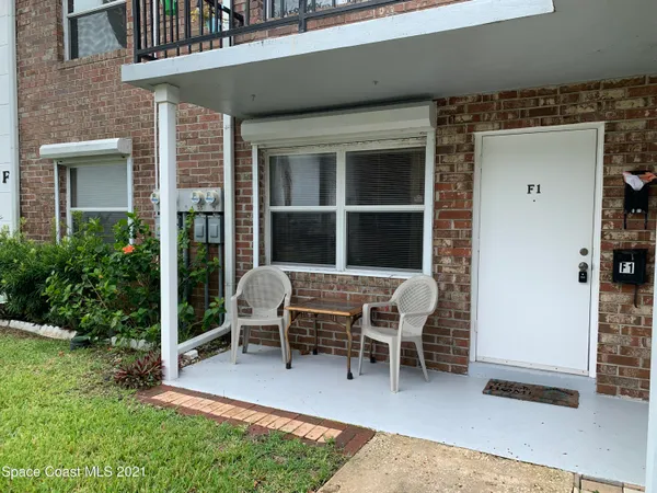 a view of a house with a patio and a yard