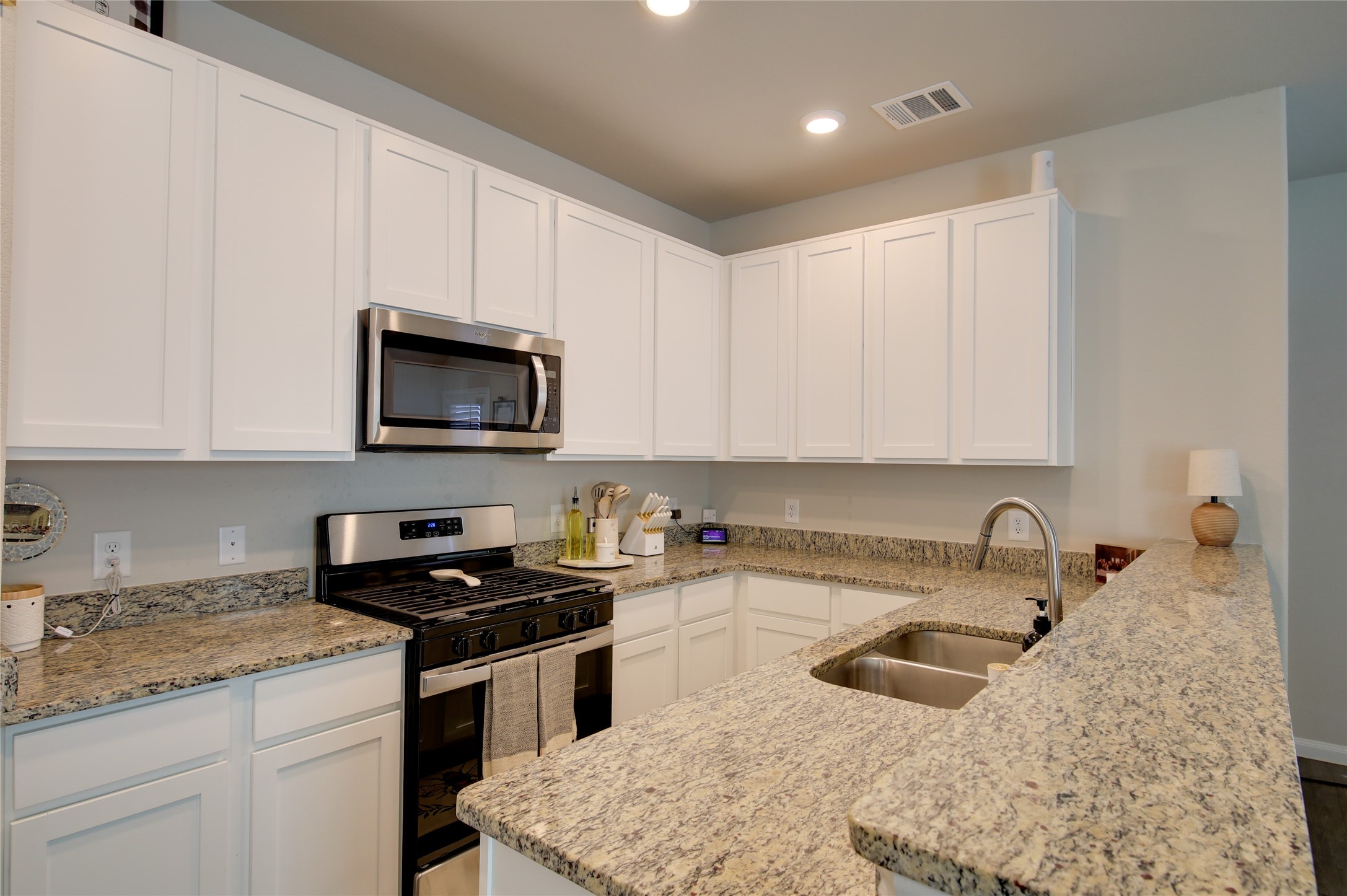 14026 Chinook Drive Conroe, TX 77384 - Photo 17 of 34 a kitchen with granite countertop white cabinets sink and stainless steel appliances