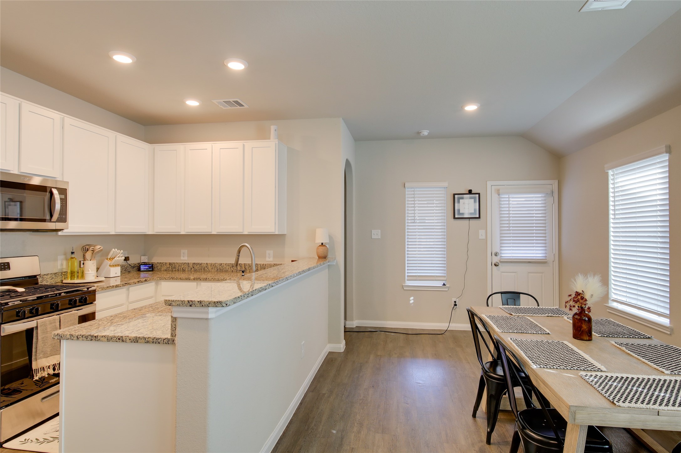 14026 Chinook Drive Conroe, TX 77384 - Photo 18 of 34 a large kitchen with stainless steel appliances granite countertop a stove a sink a refrigerator dining table and chairs