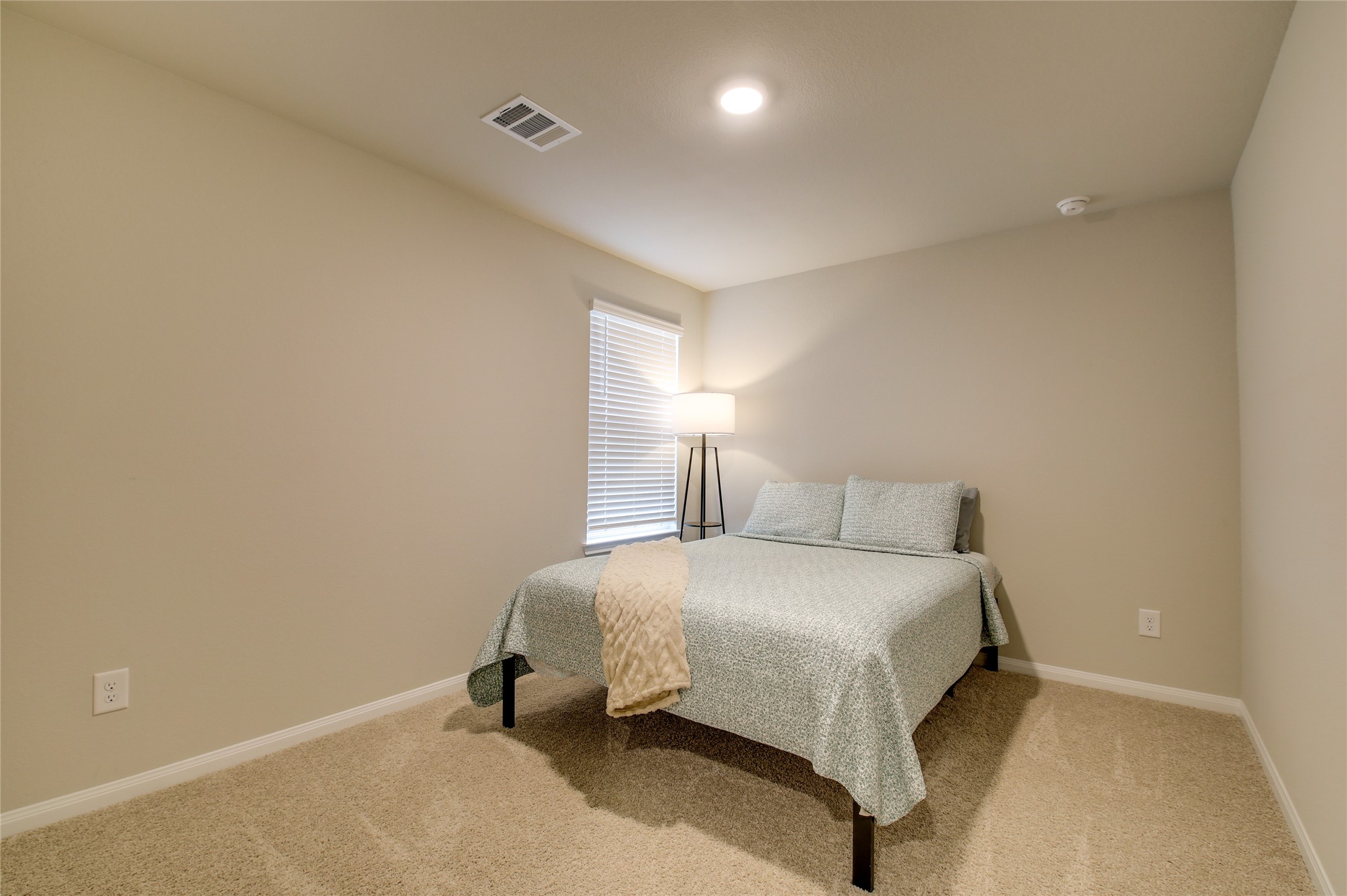 14026 Chinook Drive Conroe, TX 77384 - Photo 25 of 34 a bedroom with a bed and a lamp