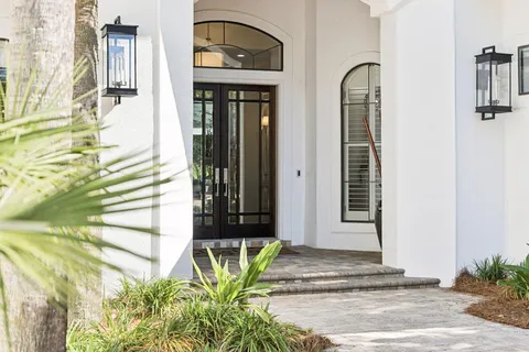 a kitchen with stainless steel appliances kitchen island granite countertop a refrigerator a stove a sink dishwasher and white cabinets with wooden floor