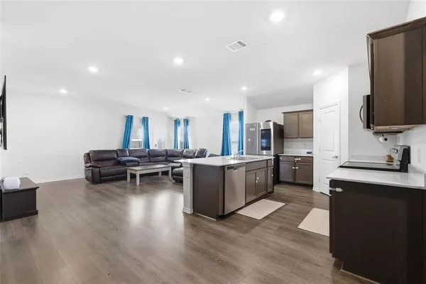 a kitchen with a sink dishwasher a stove and a refrigerator with wooden floor