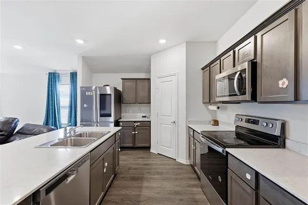 a kitchen with stainless steel appliances a sink stove and refrigerator