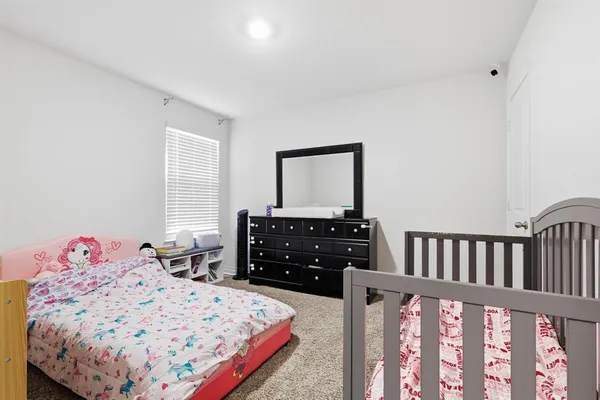 a bedroom with a bed window and dresser