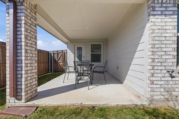 a view of a patio with table and chairs with wooden floor and fence