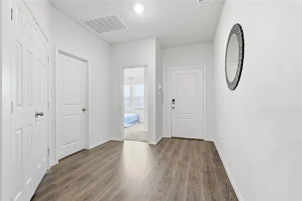 a view of a room with wooden floor and white walls