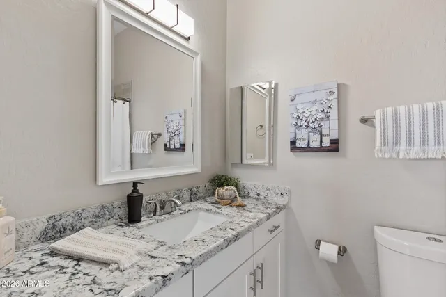 a bathroom with a granite countertop sink and a mirror