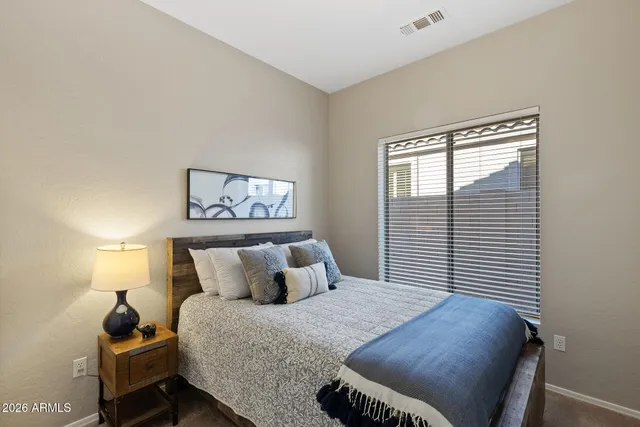 a bedroom with a bed and lamps