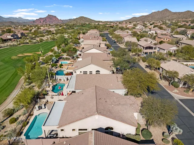 an aerial view of residential houses with outdoor space and parking