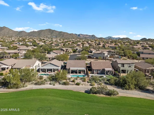 an aerial view of residential houses with outdoor space and trees