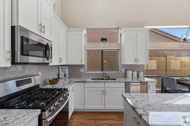 a kitchen with stainless steel appliances granite countertop a sink stove microwave and cabinets