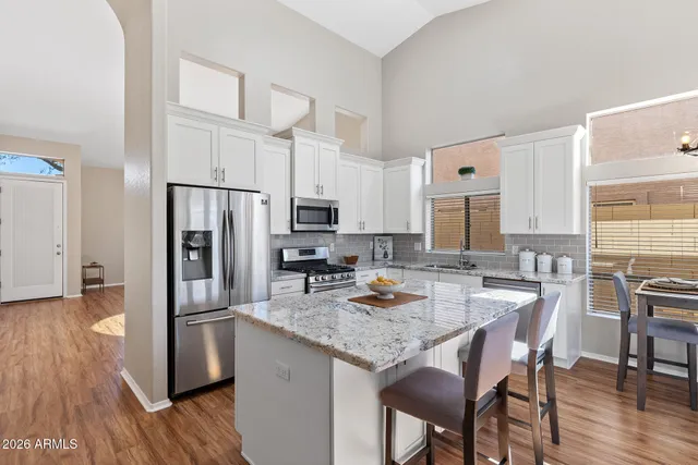 a kitchen with refrigerator cabinets dining table and chairs