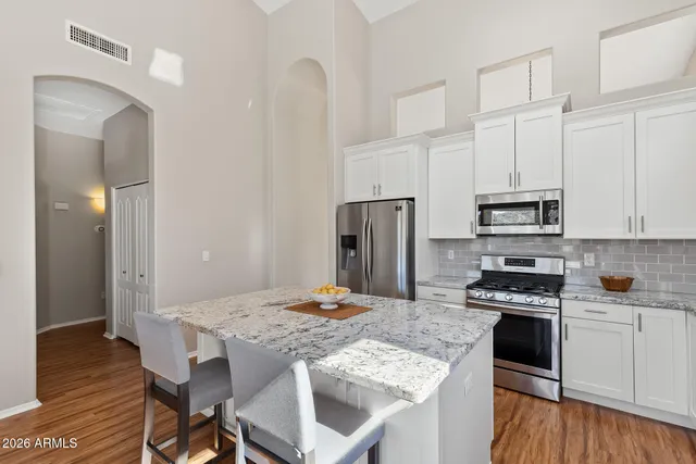 a kitchen with kitchen island granite countertop a stove a sink and a refrigerator