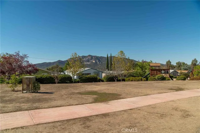 a front view of a house with a yard and trees