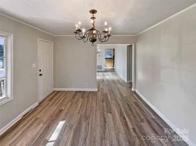 a view of a room with wooden floor and chandelier