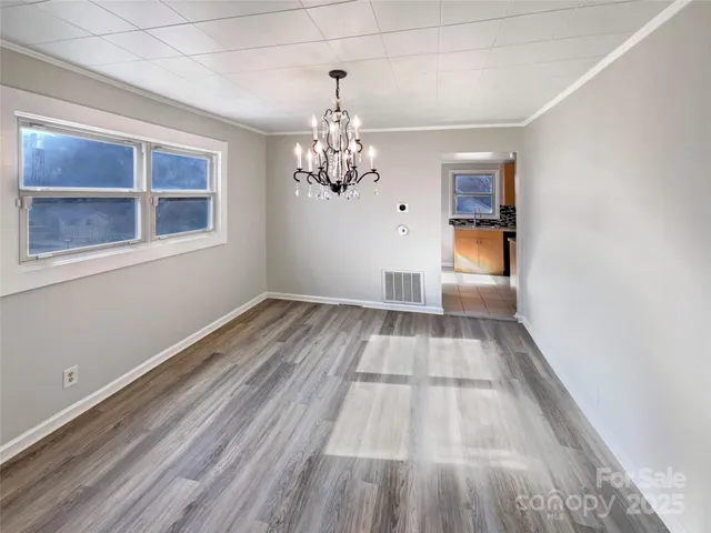 a view of a room with wooden floor and windows