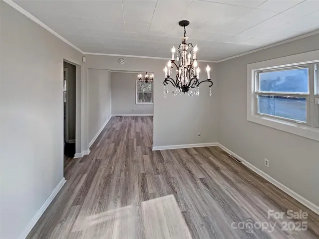 a view of a room with wooden floor and chandelier