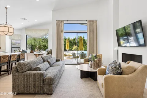 a living room with furniture potted plant and a large window