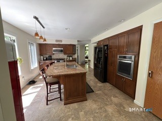 72 Pinnacle Road Ellington, CT 06029 - Photo 6 of 38 a kitchen with kitchen island a refrigerator and a stove top oven