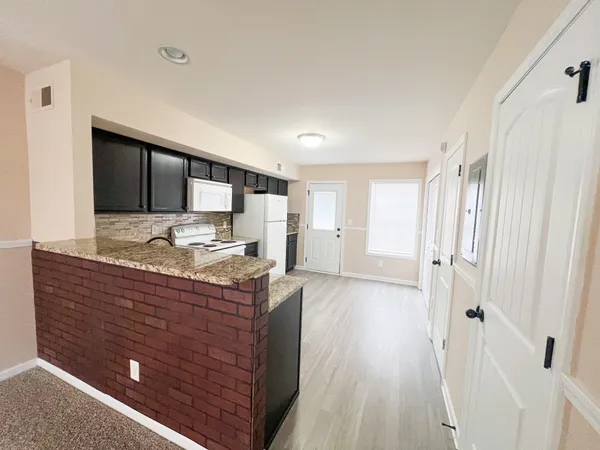 a spacious bathroom with a granite countertop sink a mirror and shower