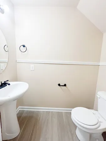 a white toilet sitting next to a white sink and vanity