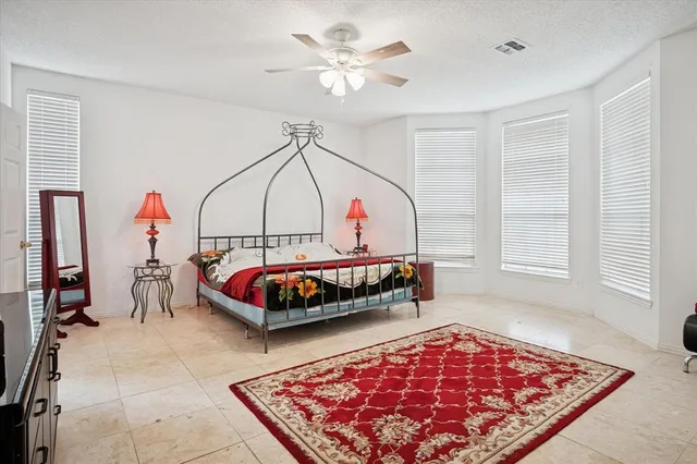 a bedroom with a bed a rug and a chandelier
