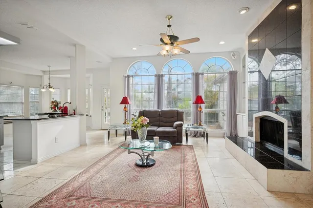 a living room with furniture a fireplace and a chandelier