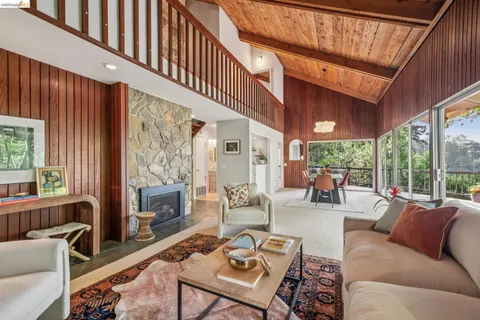 a living room with furniture a fireplace and a large window