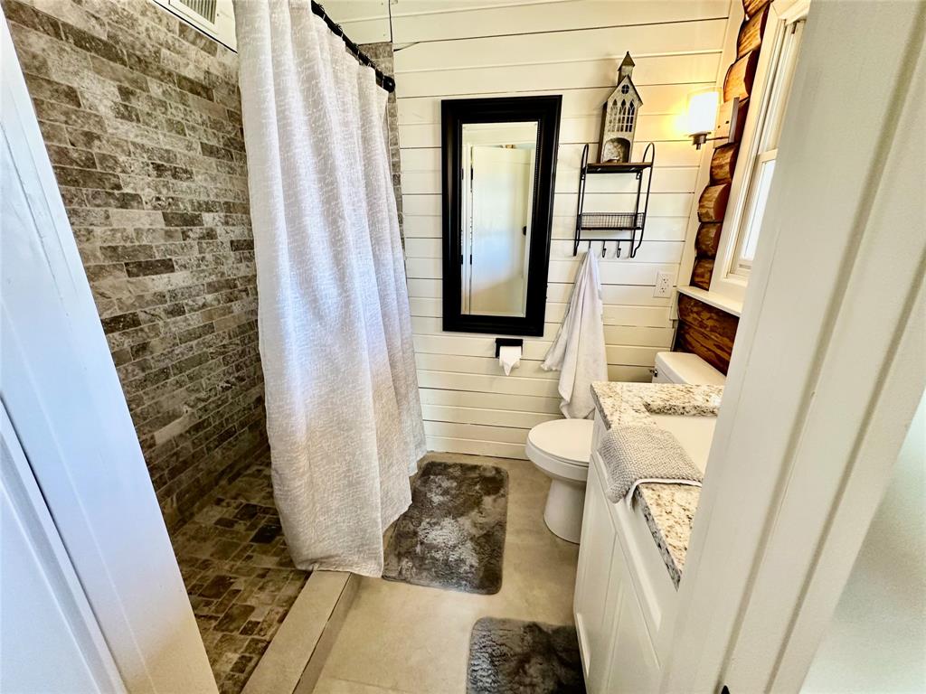 104 Advance Road Weatherford, TX 76088 - Photo 12 of 38 a bathroom with a sink and mirror with toilet