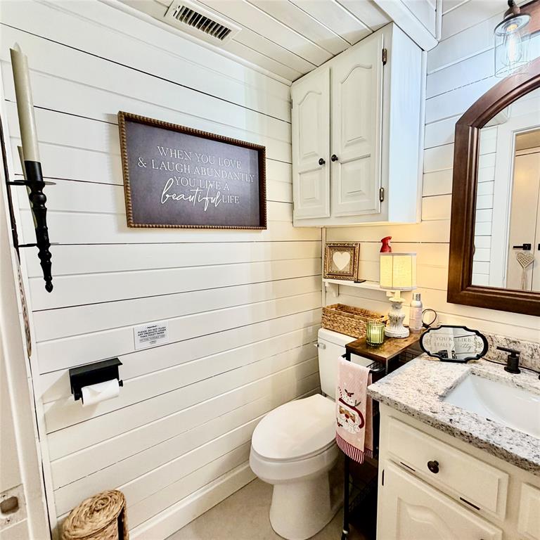104 Advance Road Weatherford, TX 76088 - Photo 15 of 38 a bathroom with a granite countertop toilet sink and mirror