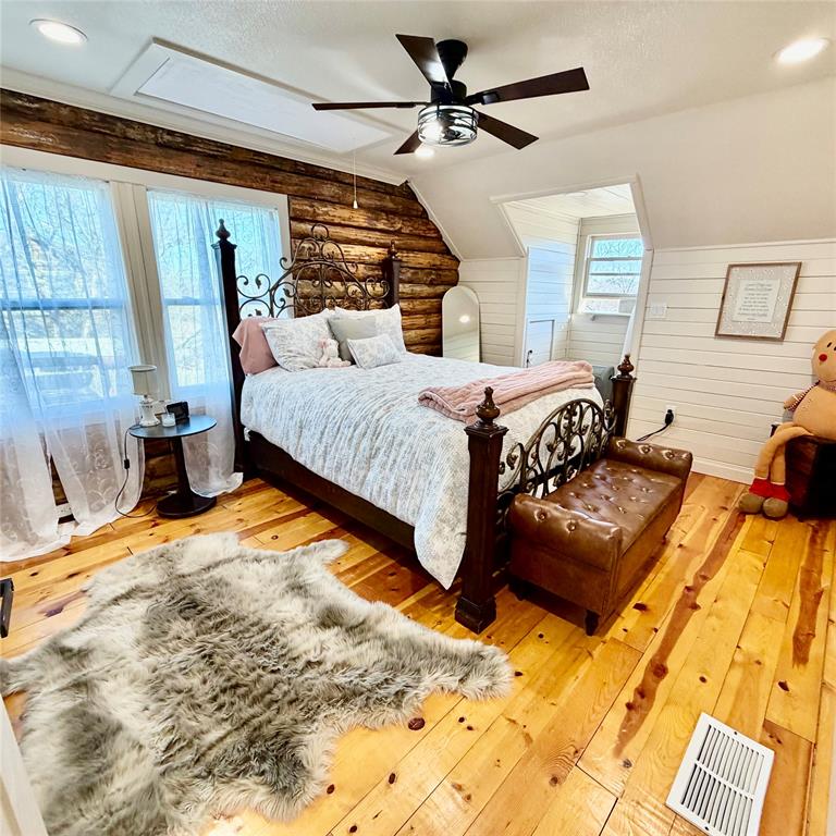 104 Advance Road Weatherford, TX 76088 - Photo 19 of 38 a bedroom with a bed and wooden floor