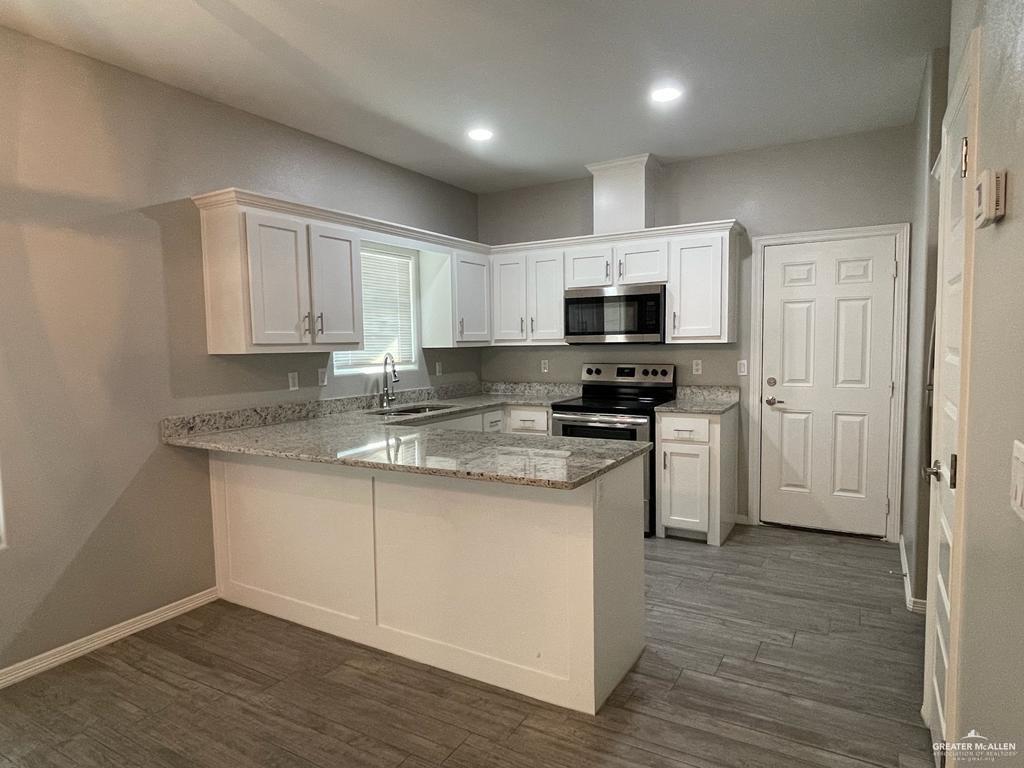 1809 Redbud Lane, Unit 3 Weslaco, TX 78596 - Photo 5 of 8 a kitchen with granite countertop a stove a sink and a microwave
