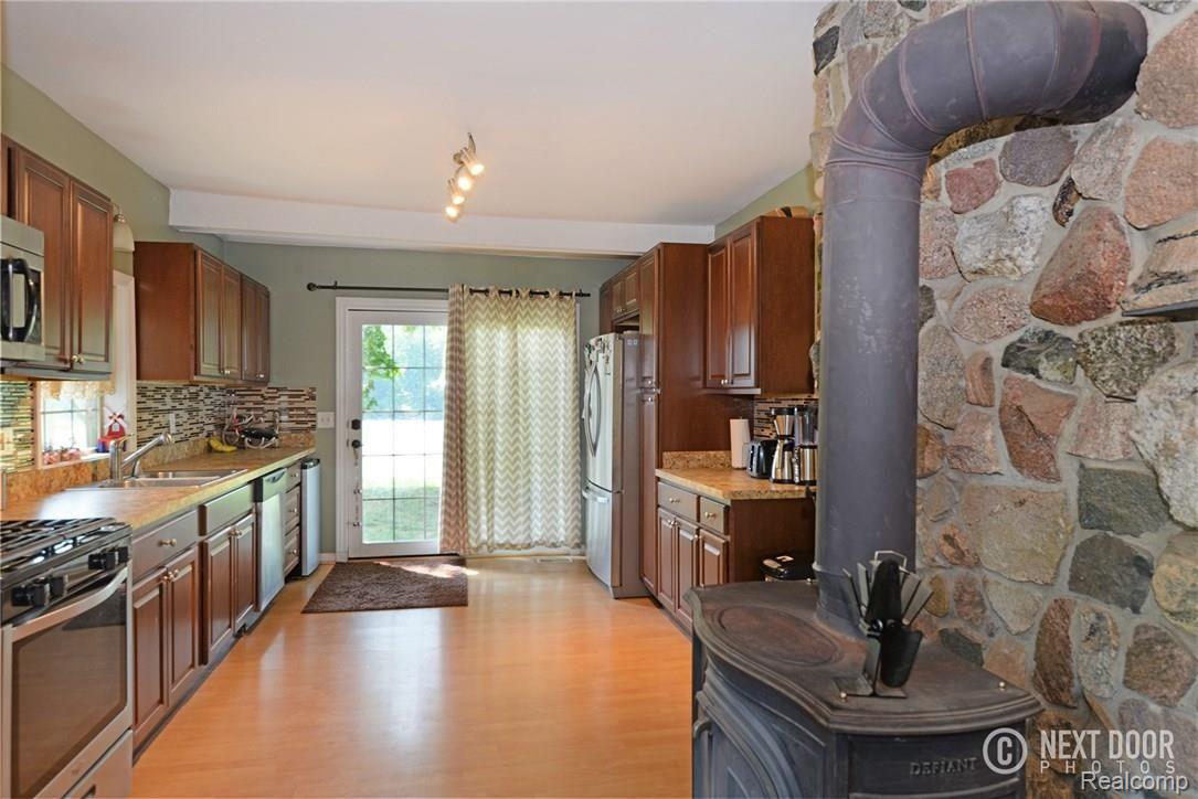 1426 Faussett Road Howell, MI 48855 - Photo 9 of 28 Wood burning stove between kitchen and living room