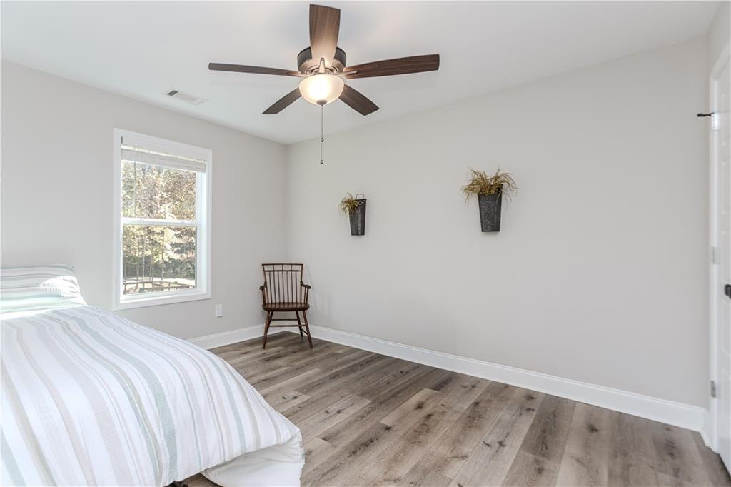 43 Water Lily Way Pendergrass, GA 30567 - Photo 20 of 71 a bedroom with a bed and a chandelier