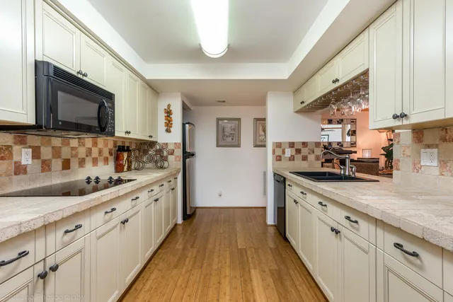 a large kitchen with stainless steel appliances granite countertop a lot of counter space and wooden floors
