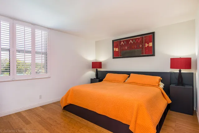 a bed sitting in a bedroom next to a window