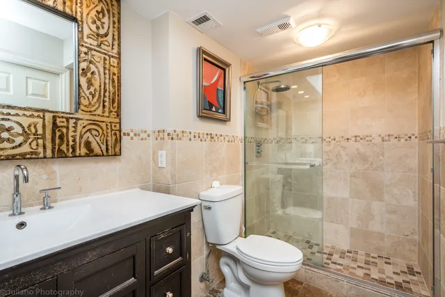 a bathroom with a sink a toilet a shower and a mirror